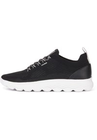Zapatilla negra con parte superior de malla transpirable, suela blanca acolchada y detalles texturizados. Presenta cordones negros con acentos reflectantes.