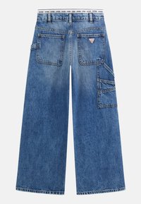 Jeans en denim à jambe large en bleu moyen avec une finition délavée. Comprend plusieurs poches, des coutures contrastées et une ceinture de marque.