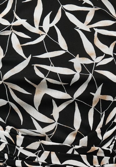 Μαύρο ύφασμα με λευκό αφηρημένο μοτίβο φύλλων και μαζεμένες ραφές κοντά στην κάτω άκρη.