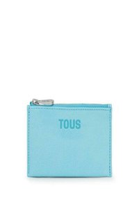 Billetera de cuero azul con una textura suave, que presenta un zipper plateado y el logo en relieve "TOUS" en la parte frontal. Forma rectangular compacta.