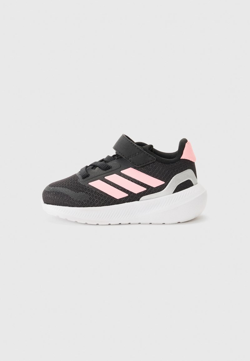 Chaussure de sport noire avec des accents roses, tige en mesh respirant, col rembourré et semelle en caoutchouc blanche. Équipée d'une sangle velcro pour la fermeture.