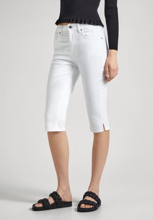 Beli denim capri hlače s stranskimi razpoki, ki imajo klasičen pet-pocket dizajn. Ujemajo se z črnimi pletenimi sandalami.
