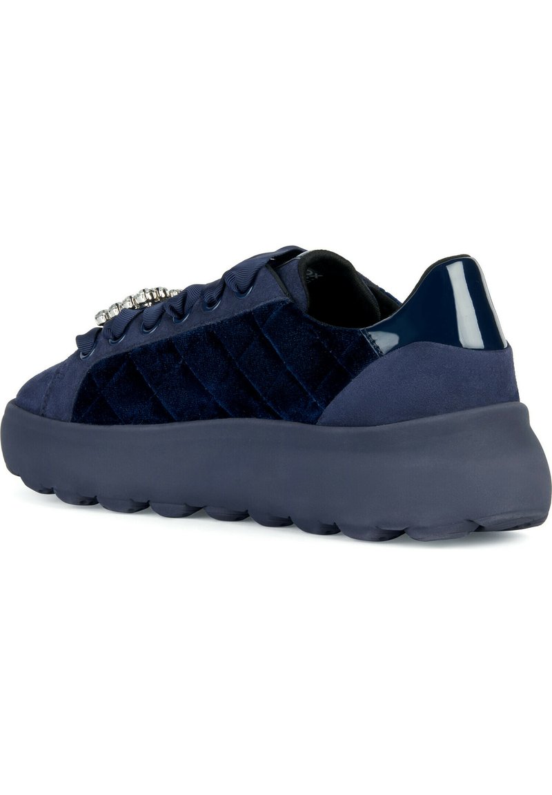 Sneakers blu navy con tomaia in velluto texture, dettagli in vernice e una suola in gomma spessa. Presentano lacci decorati e un design trapuntato.