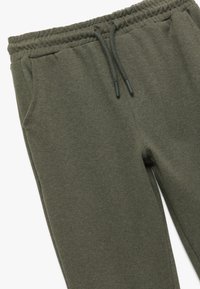 Donkergroene joggers gemaakt van textiel met structuur, voorzien van een elastische tailleband met trekkoord en zijzakken.