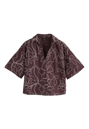 Blouse courte manches violet foncé avec motifs floraux abstraits blancs en lignes et col en V large et ouvert.