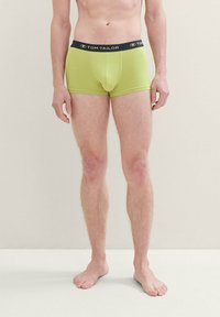 Zöld pamut boxer alsónadrág fekete derékkal, amelyen a "TOM TAILOR" logó található. Simaság jellemzi, testhezálló fazonú és a comb közepéig ér.