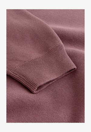 Pehmeast lilla kudumkangast kampsun, millel on soonikkoes mansett ja sile, tekstureeritud pind, ilma nähtavate mustrite või kaunistusteta.