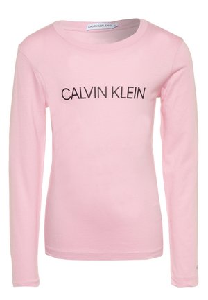 Lyserød langærmet skjorte med rund halsudskæring og sort "CALVIN KLEIN" tekst trykt hen over brystet.