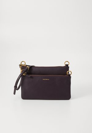Dark purple leather bag with dual compartments, gold hardware accents, textured surface, and a curved strap for easy carrying.