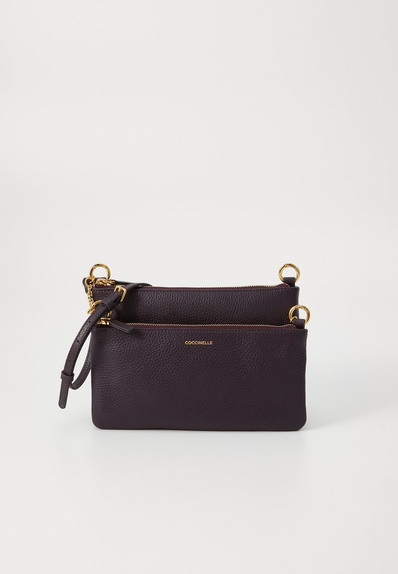 Borsa in pelle di un viola scuro con doppie compartimenti, dettagli in metallo dorato, superficie texture, e una tracolla curva per un trasporto facile.