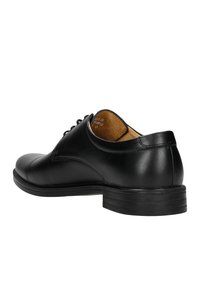 Scarpa in pelle nera con punta rotonda, design allacciato, finitura liscia e tacco basso impilato. L'interno presenta una fodera marrone chiaro.