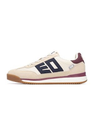 Zapatilla deportiva beige con detalles en azul marino, parte superior de ante texturizado y malla, suela de goma y lengüeta en el talón color burdeos, con un logotipo destacado en el lateral.