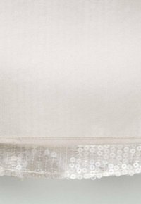 Witte stof met een doorschijnende zoom versierd met een reeks witte pailletten die in verticale rijen zijn gerangschikt.