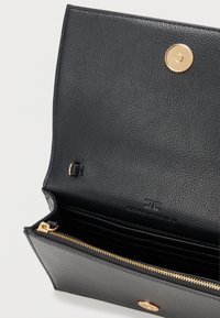 Μαύρο δερμάτινο πορτοφόλι με υφή, με κλείσιμο με χρυσό κουμπί και φερμουάρ σε θήκη. Διάφορες θήκες για κάρτες είναι ορατές στην εσωτερική πλευρά.