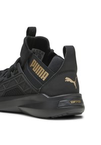 Zapato deportivo negro con parte superior texturizada, diseño geométrico, logo dorado de PUMA y detalle de "SOFTRIDE" en el talón.