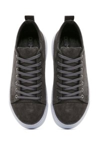 Sneaker in suede grigio con design a bassa scarpa, dotati di lacci grigi e una suola in gomma bianca. Texture liscia con accenti minimalisti.