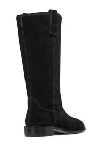 Bota de ante negra hasta la rodilla con punta redondeada, detalles de costura, un pequeño tacón y un lazo en la parte superior para facilitar el calzado.