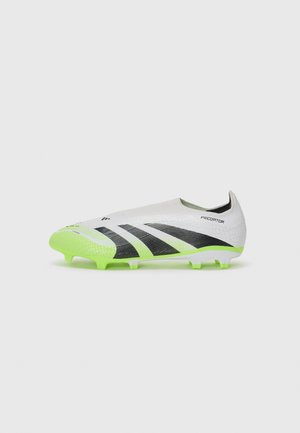 Botte de football blanche avec accents noirs et semelle vert lime. Présente une texture lisse et un ajustement serré. Conçue pour la performance sur les surfaces en gazon.
