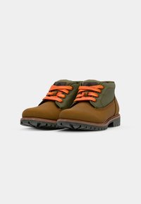 Bottines brunes et vertes avec des lacets orange, semelle en caoutchouc avec un motif de crantage, matière supérieure lisse, col rembourré et étiquette de logo.