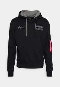 Felpa nera con cappuccio foderato in grigio, tasca frontale, logo dei Tampa Bay Buccaneers e un'etichetta rossa sulla manica. Realizzata in tessuto morbido.