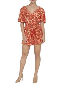 Robe salopette rouge avec un motif de feuilles, manches courtes, décolleté en V, taille cintrée et détail à nouer. Portée avec des talons nus.