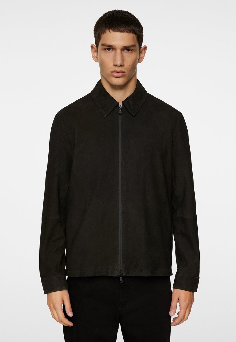 Zwarte suede jas met een kraag en volledige rits aan de voorkant. Beschikt over lange mouwen en een rechte snit met minimale stikdetails.