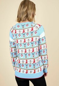 Pulover tricotat de culoare albastră deschisă, cu modele festive de fețe de Moș Crăciun și reni, cu manșete și tiv cu nervuri, pe un fundal neutru.