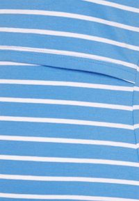 Randig blå och vit t-shirt med korta ärmar, med en bröstficka och mjuk bomullstextur. Horisontella ränder i varierande bredd.