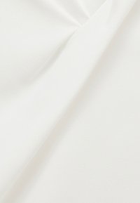 Tessuto bianco con una finitura morbida e testurizzata, caratterizzato da pieghe e drappeggi sottili. Il materiale appare leggero e liscio.