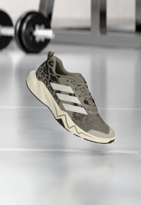 Αθλητικό παπούτσι σε ταμπά χρώμα με λεπτομέρειες σε σχέδιο λεοπάρδαλης, υφασμένο άνω μέρος, κλείσιμο με κορδόνια και σόλα με σχέδιο ζιγκ-ζαγκ. Διαθέτει τρεις λευκές ρίγες στο πλάι.