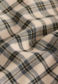 Karo-Stoff in Beige, Grau und Schwarz mit metallischen Goldakzenten. Strukturierter Webstuhl mit ausgeprägten quadratischen Mustern und glatter Oberfläche.