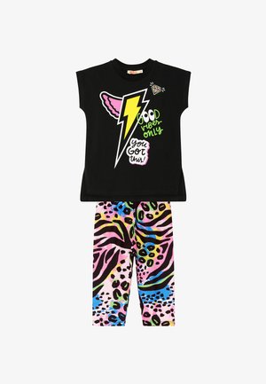 Top negro de manga corta con un rayo colorido y texto gráfico. Leggings de estampado animal multicolor con patrones en rosa, negro y azul.