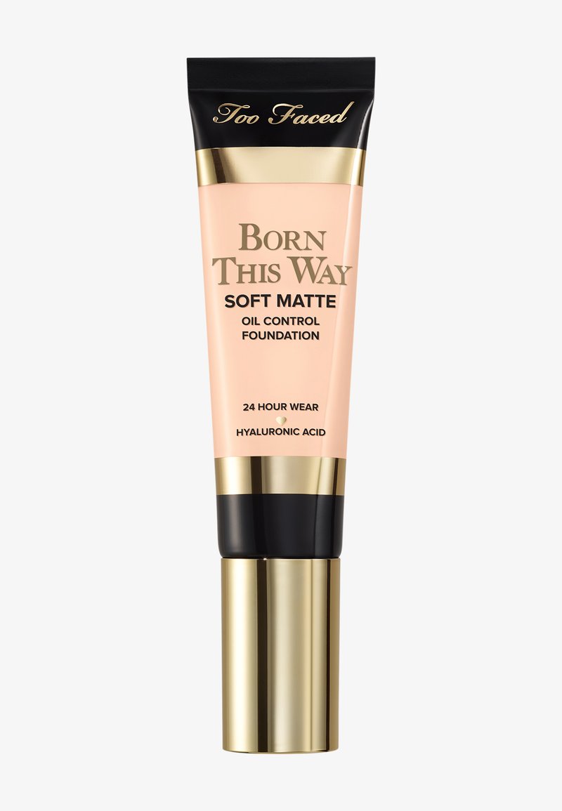 Too Faced Born This Way Soft Matte Oil Control Foundation Tube mit gold-schwarzem Deckel, beschriftet mit 24 Stunden Halt und Hyaluronsäure.