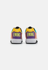 Baskets colorées avec une tige en cuir et en synthétique. Les caractéristiques incluent des accents jaunes, violets et bleus, ainsi que le logo « EWING » sur le talon.