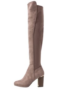 Botas hasta la rodilla en color topo, combinando materiales de ante y tela, con tacón grueso, textura suave y una silueta elegante. Detalle en tono dorado en el tacón.