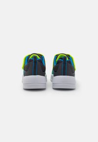 Vue arrière de chaussures de sport présentant un design noir avec des accents bleus et vert néon, un dessus texturé et des semelles blanches perforées.
