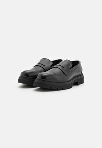 Black leather loafers with a smooth finish, wide strap detail, and a thick rubber sole featuring a ridged texture. Seam stitching accents.