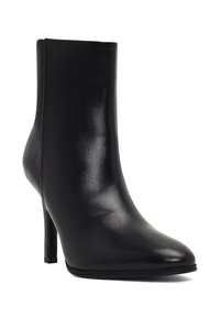 Bottine en cuir noir avec un bout pointu et un talon stiletto élancé. Texture lisse, design minimalist et silhouette élégante.