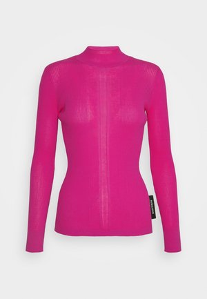 Pull ajusté à manches longues en maille côtelée rose vif avec col montant et détails texturés verticaux, doté d'une étiquette de marque sur le côté.