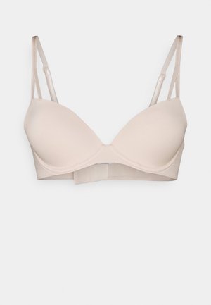 Lichtbeige beha met gladde, gevormde cups, verstelbare banden en een platte rugband. Gemaakt van zachte stof met een naadloos ontwerp.