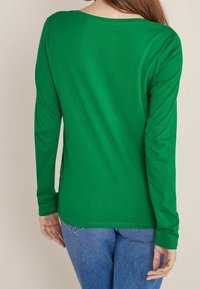 Long-sleeve green T-shirt with a rounded neckline, made of soft fabric. Features a relaxed fit and straight hemline, suitable for casual wear.