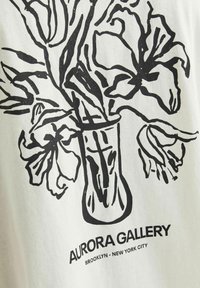 Tissu blanc avec un dessin au trait noir d'un vase avec des fleurs, accompagné du texte : "AURORA GALLERY, BROOKLYN - NEW YORK CITY."