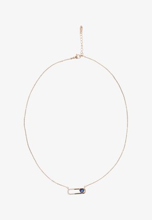 Gouden ketting met een veiligheidsspeld hanger, versierd met een blauwe hart en kleine heldere edelsteentjes aan één kant.