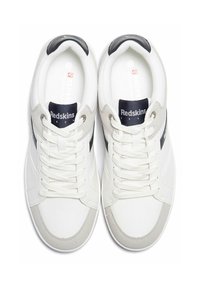 Baskets blanches à finition texturée, avec un accent en suède gris, un logo bleu marine sur la languette et des lacets blancs plats.
