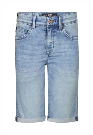 Dreng iført en koralrosa poloshirt med små print, lyseblå opkørte denimshorts, hvide sokker med sorte striber og hvide sneakers.