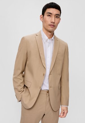Beige Sakko mit taillierter Passform, Reverskragen, einer Brusttasche und goldenen Knöpfen, kombiniert mit einem weißen Button-Down-Hemd.