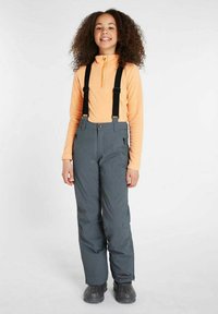 Grijze waterdichte broek met zwarte bretels, gecombineerd met een oranje langetermijnshirt. De broek heeft een ritszak en versterkte naden.
