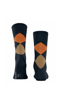 Granatowe skarpetki z wzorem w diamenty w kolorze pomarańczowym i beżowym, z prążkowanym ściągaczem i wzmocnioną piętą. Wykonane z mieszanki bawełny dla komfortu.