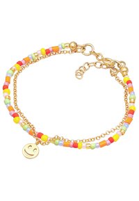 Bracelet en chaîne dorée avec des perles colorées en rose, jaune, vert et orange, agrémenté d'un petit charm en forme de visage souriant en or.