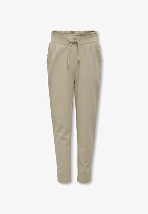 Pantalons de jogging beiges avec une taille élastique froncée, une fermeture à cordon de serrage et des poches latérales ornées de volants. Texture lisse sur l'ensemble.